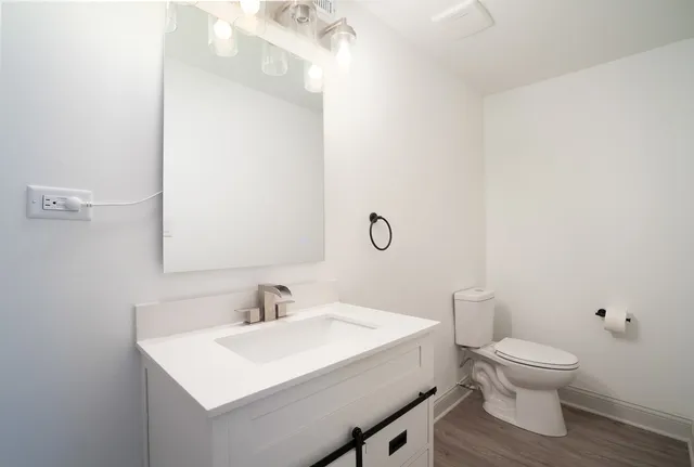a bathroom with a toilet a sink and a mirror
