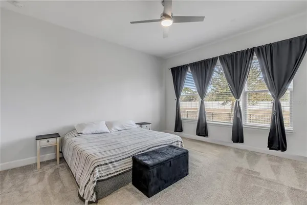 a spacious bedroom with a large bed closet and large window