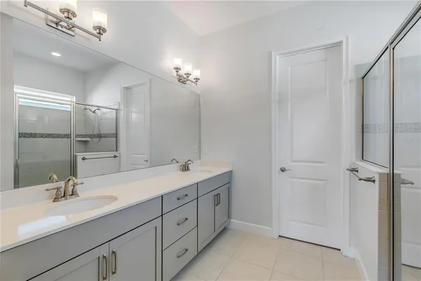 a bathroom with a double vanity sink mirror and shower