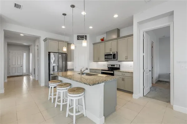 a kitchen with cabinets and chairs