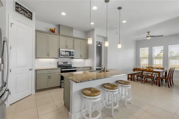 a kitchen with appliances cabinets and chairs