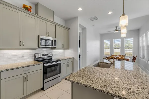 a kitchen with stainless steel appliances granite countertop a sink stove and cabinets