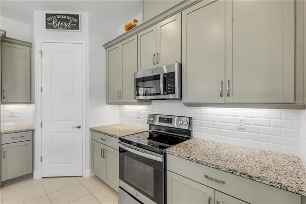 a kitchen with granite countertop white cabinets and stainless steel appliances