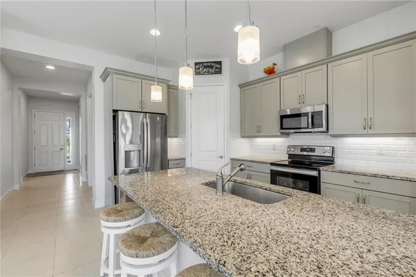 a kitchen with stainless steel appliances granite countertop a sink refrigerator and cabinets