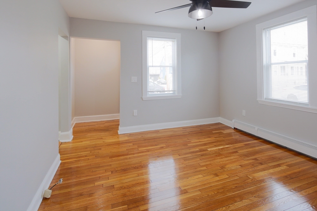 259 Calvary Street, Unit 1 Waltham, MA 02453 - Photo 11 of 27 wooden floor in an empty room with a window