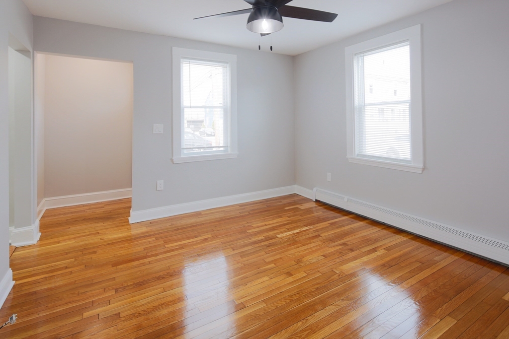 259 Calvary Street, Unit 1 Waltham, MA 02453 - Photo 12 of 27 a view of empty room with wooden floor and fan