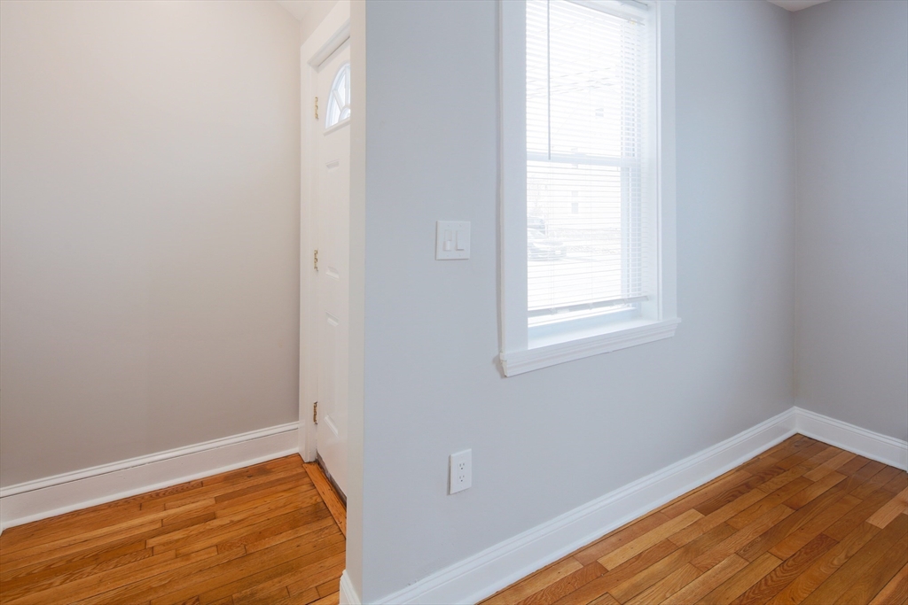 259 Calvary Street, Unit 1 Waltham, MA 02453 - Photo 13 of 27 a view of empty room with wooden floor and fan