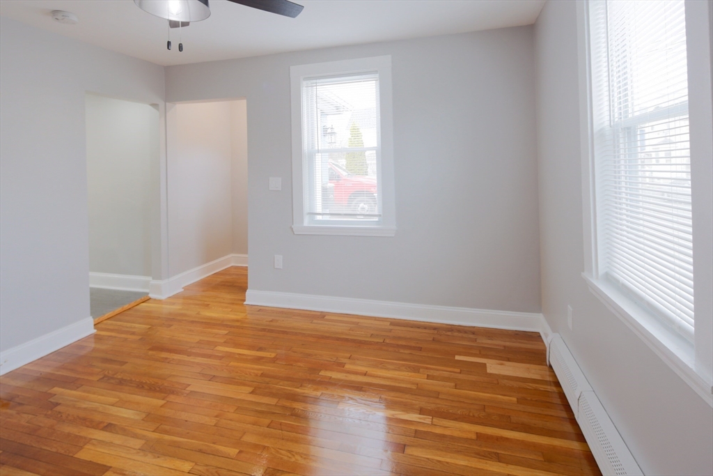 259 Calvary Street, Unit 1 Waltham, MA 02453 - Photo 14 of 27 a view of empty room with wooden floor and fan