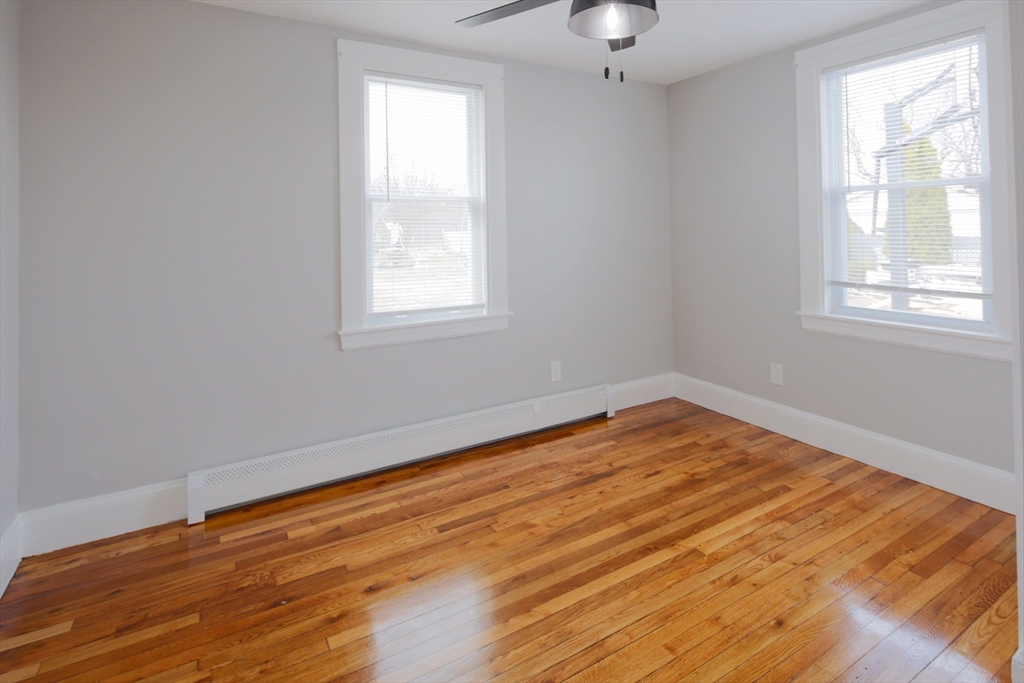 259 Calvary Street, Unit 1 Waltham, MA 02453 - Photo 20 of 27 a view of empty room with wooden floor and fan