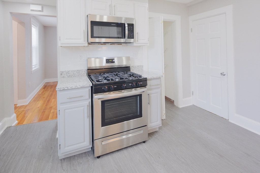 259 Calvary Street, Unit 1 Waltham, MA 02453 - Photo 2 of 27 a kitchen with a stove and a microwave