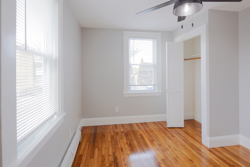259 Calvary Street, Unit 1 Waltham, MA 02453 - Photo 21 of 27 a view of empty room with wooden floor and fan