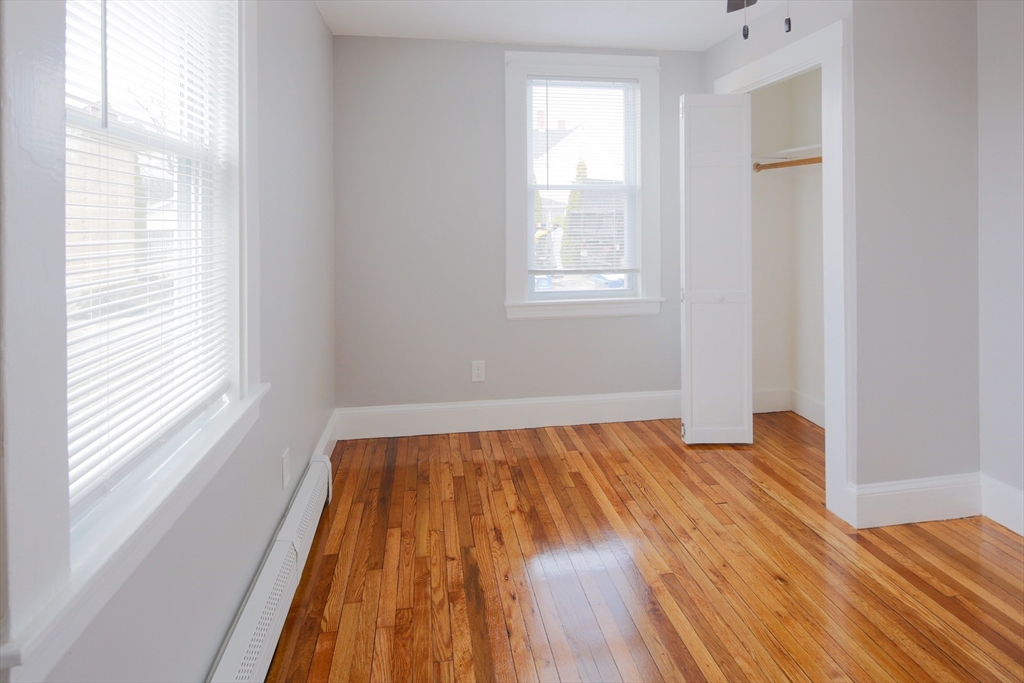 259 Calvary Street, Unit 1 Waltham, MA 02453 - Photo 22 of 27 a view of a bedroom with wooden floor and window