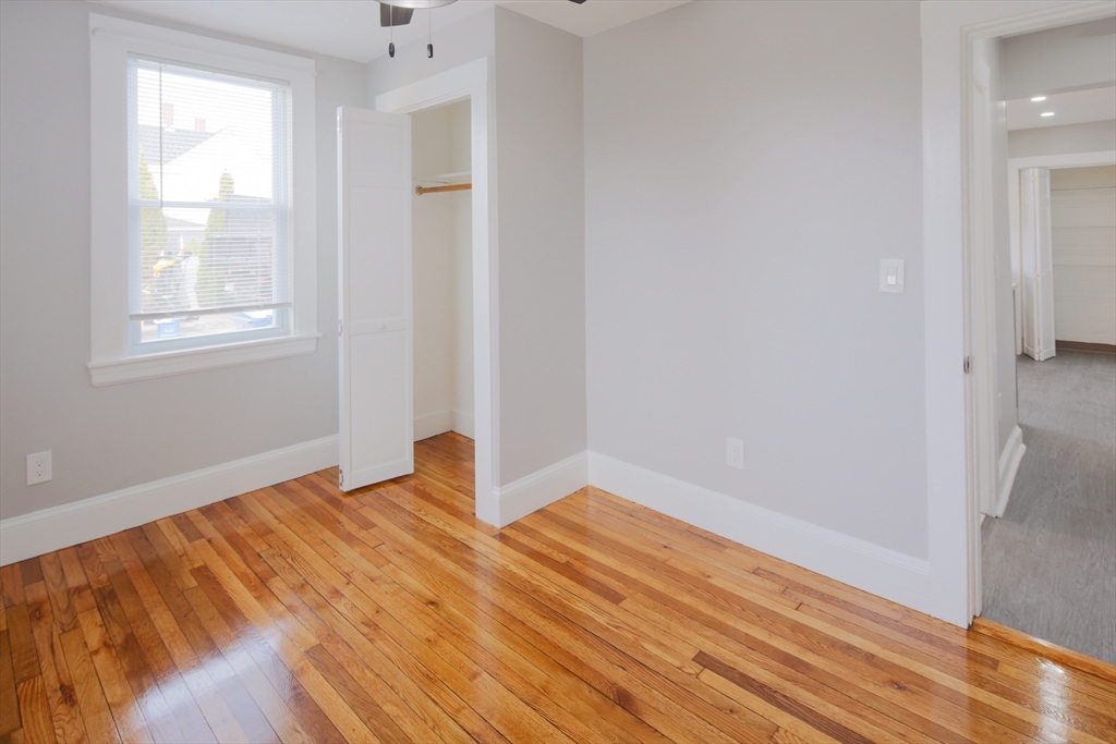 259 Calvary Street, Unit 1 Waltham, MA 02453 - Photo 23 of 27 a view of an empty room with wooden floor and a window