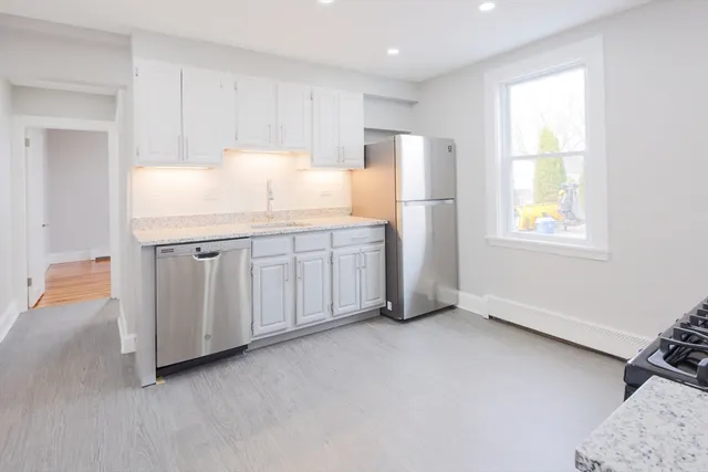 a kitchen with stainless steel appliances a refrigerator sink and cabinets