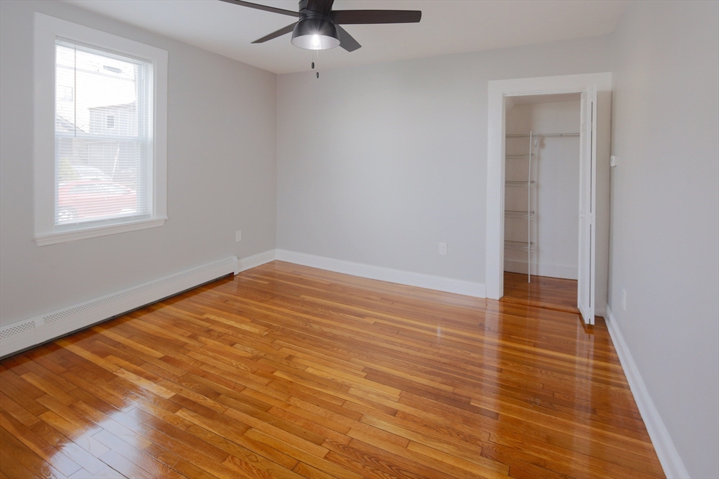 259 Calvary Street, Unit 1 Waltham, MA 02453 - Photo 8 of 27 wooden floor in an empty room with a window