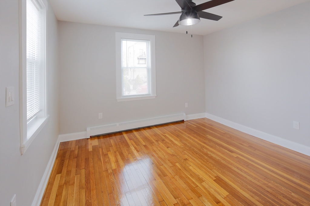 259 Calvary Street, Unit 1 Waltham, MA 02453 - Photo 9 of 27 an empty room with a window and ceiling fan