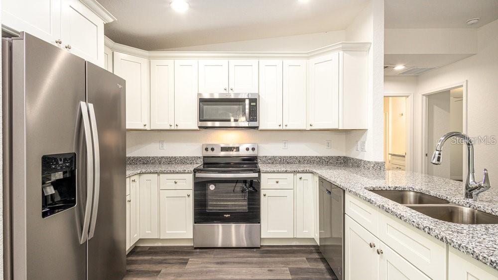 151 Malauka Road Ocklawaha, FL 32179 - Photo 14 of 29 a kitchen with stainless steel appliances granite countertop a refrigerator stove and sink