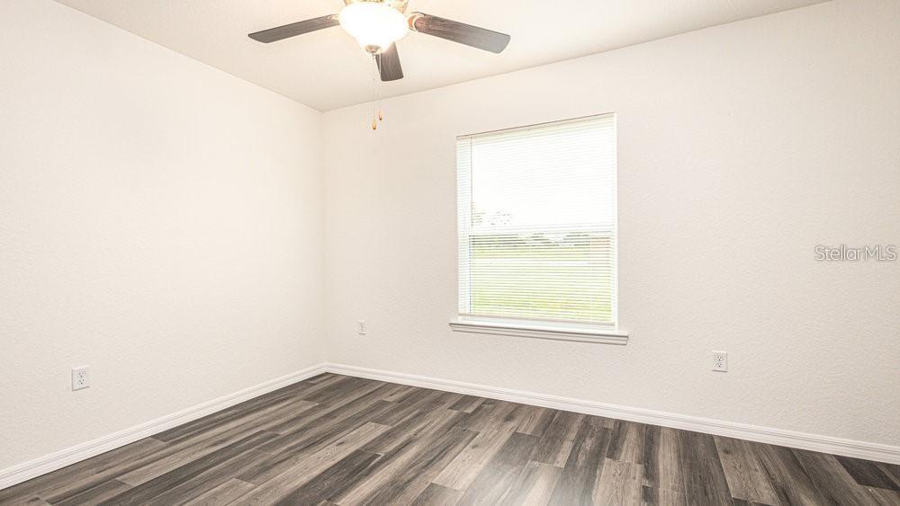 151 Malauka Road Ocklawaha, FL 32179 - Photo 16 of 29 an empty room with a window and wooden floor