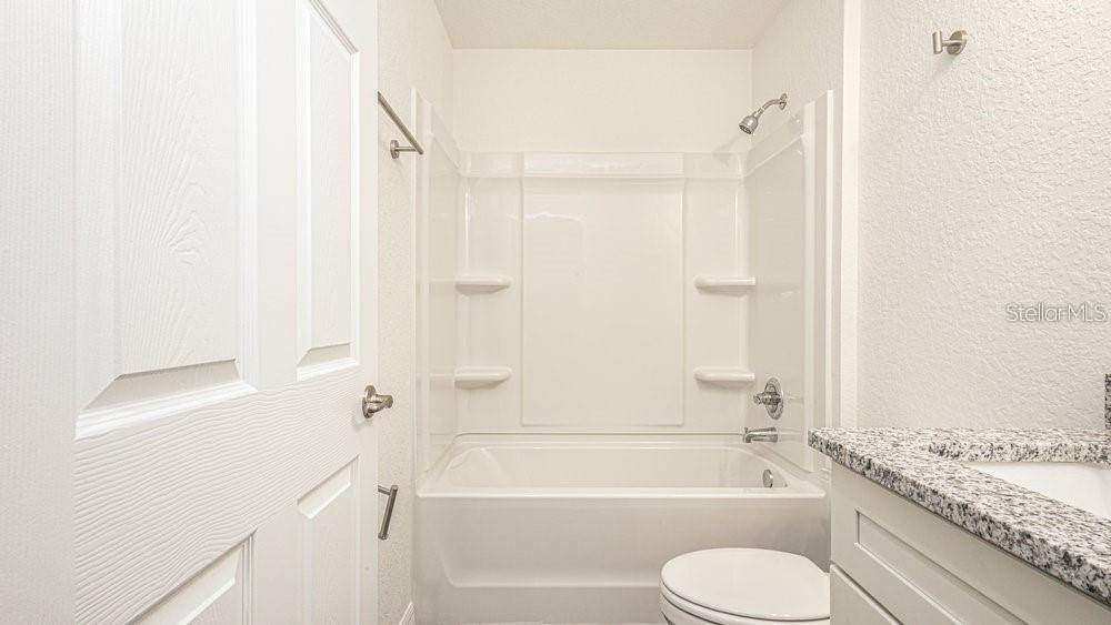 151 Malauka Road Ocklawaha, FL 32179 - Photo 19 of 29 a bathroom with a granite countertop bathtub shower sink vanity and toilet