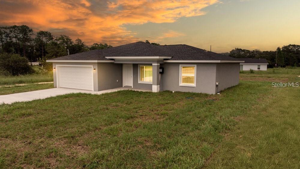 151 Malauka Road Ocklawaha, FL 32179 - Photo 2 of 29 a front view of a house with a yard and garage