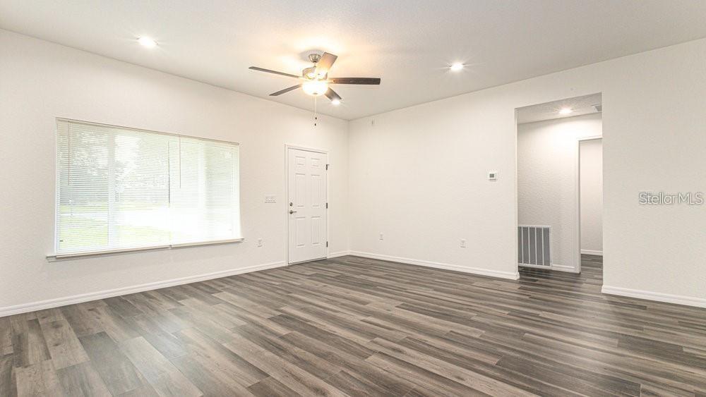 151 Malauka Road Ocklawaha, FL 32179 - Photo 22 of 29 a view of an empty room with wooden floor and a window