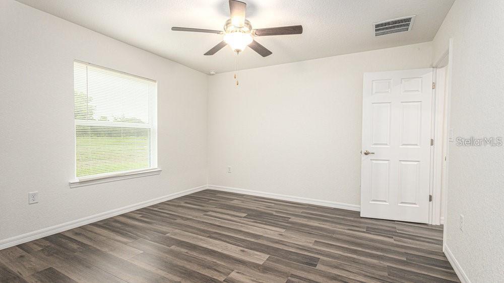 151 Malauka Road Ocklawaha, FL 32179 - Photo 27 of 29 an empty room with a window and a ceiling fan