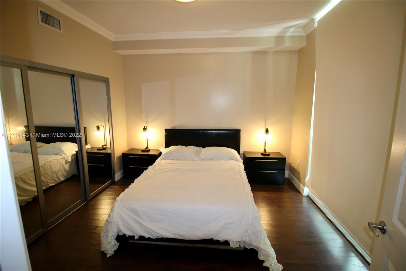 275 Northeast 18th Street, Unit 306 Miami, FL 33132 - Photo 9 of 15 a bedroom with a bed and wooden floor