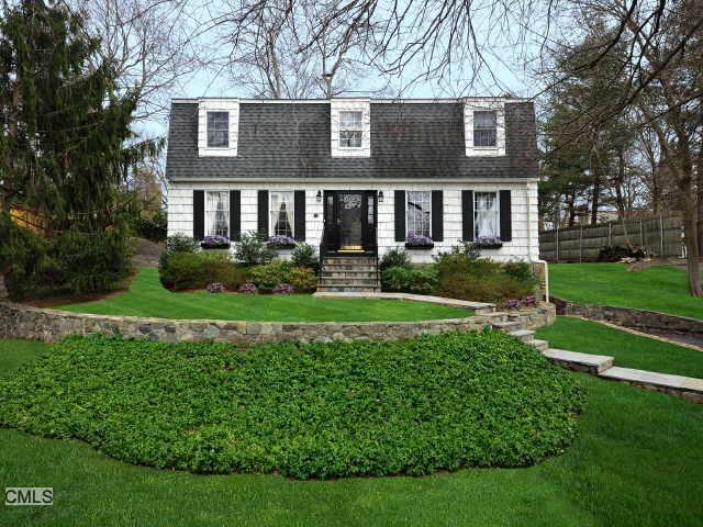 a front view of a house with a yard and green space