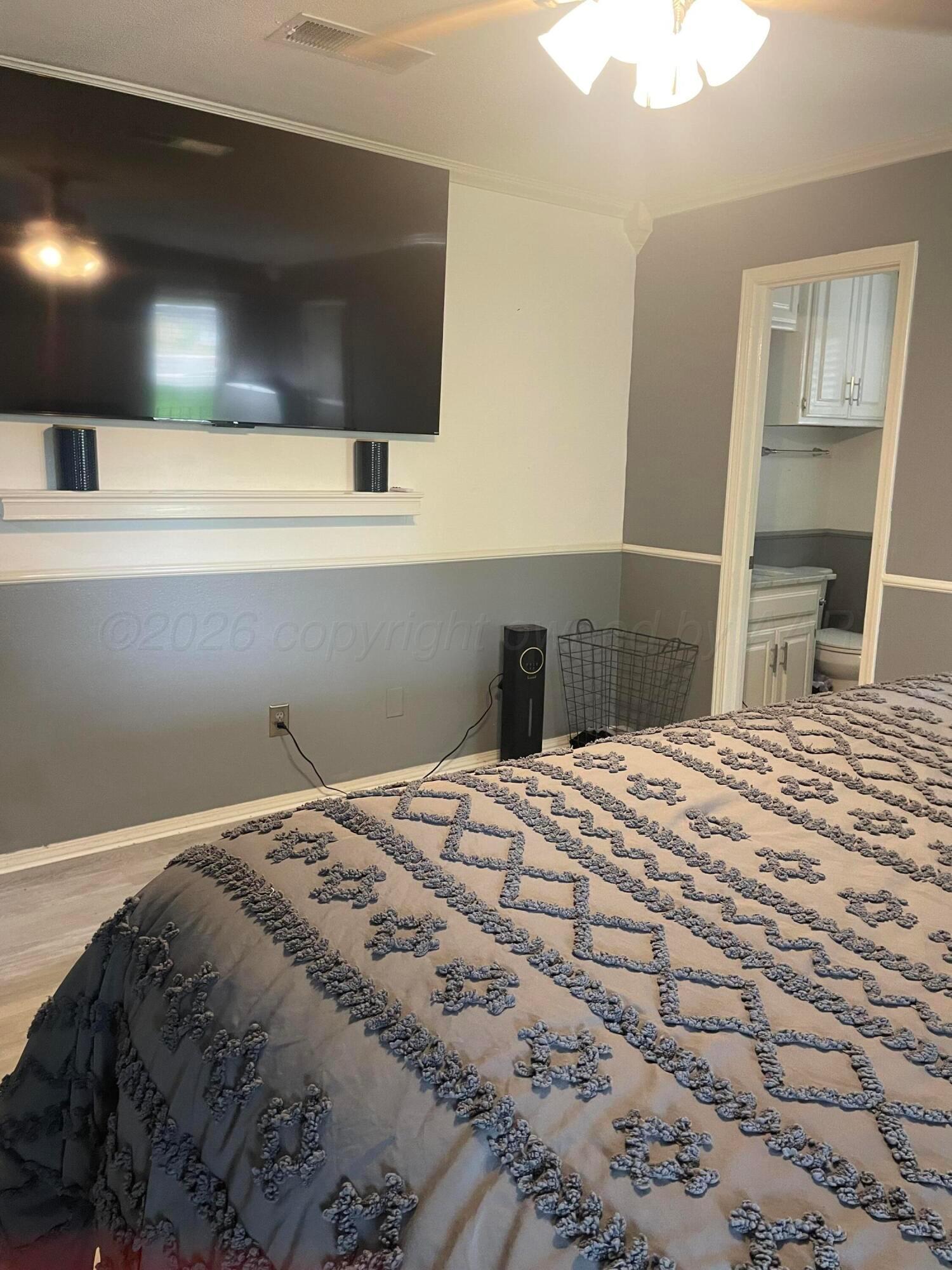 6716 Brookview Way Amarillo, TX 79124 - Photo 11 of 15 a bedroom with a bed and a flat screen tv