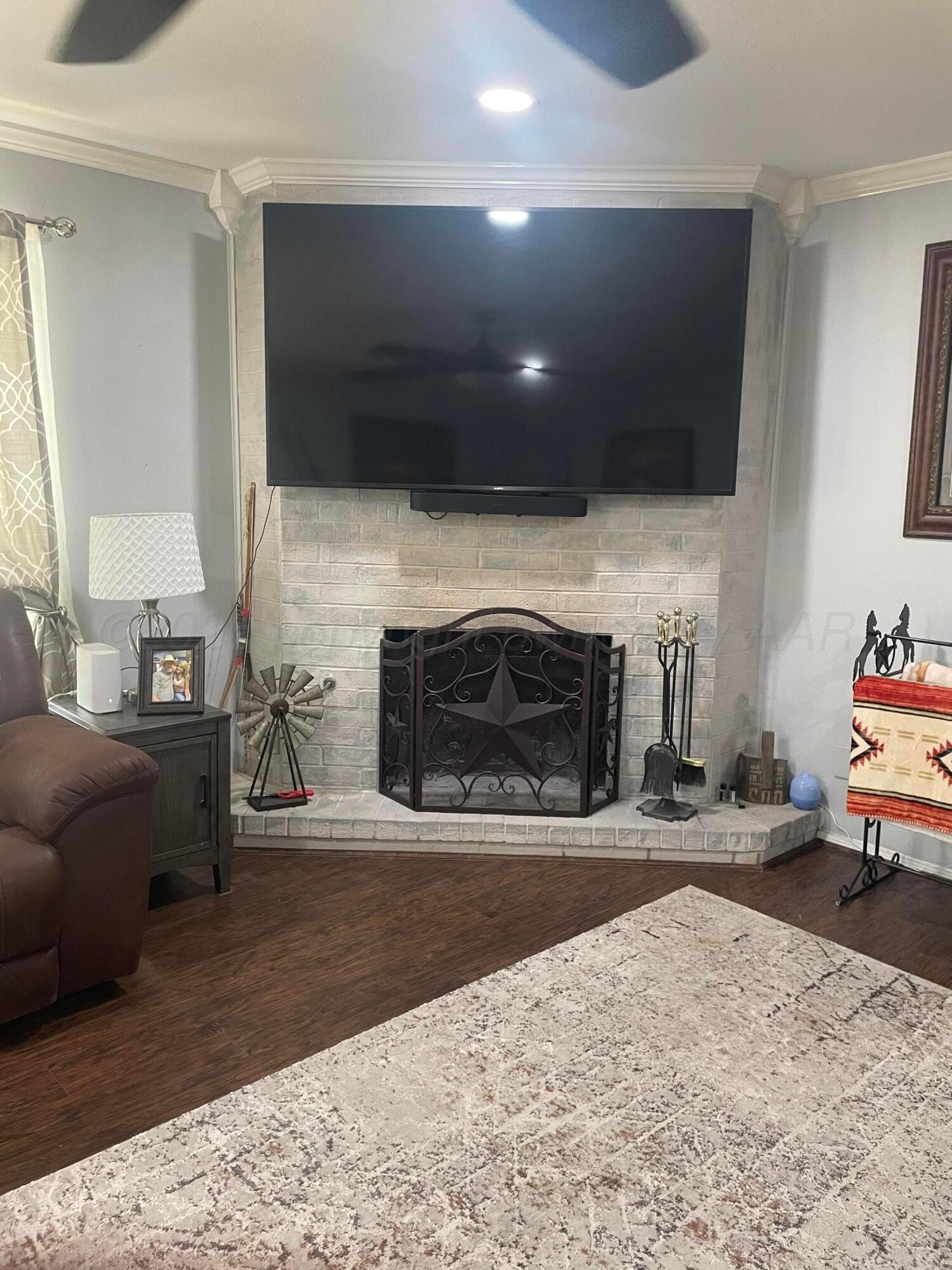 6716 Brookview Way Amarillo, TX 79124 - Photo 6 of 15 a living room with fireplace furniture and a flat screen tv