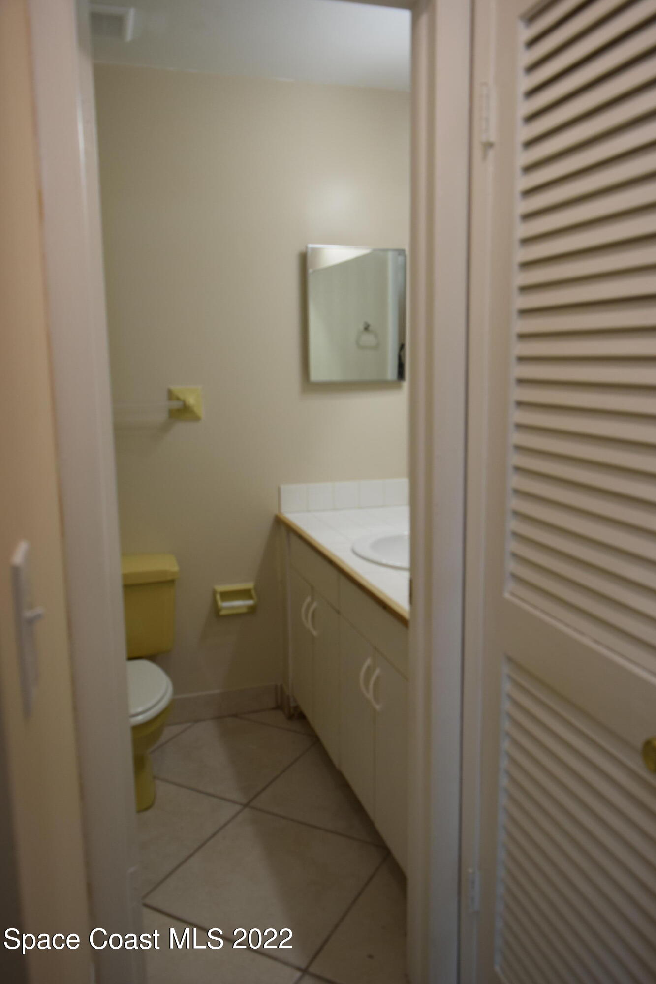 771 Cobblestone Lane Northeast Palm Bay, FL 32905 - Photo 19 of 30 a bathroom with a granite countertop toilet and a sink