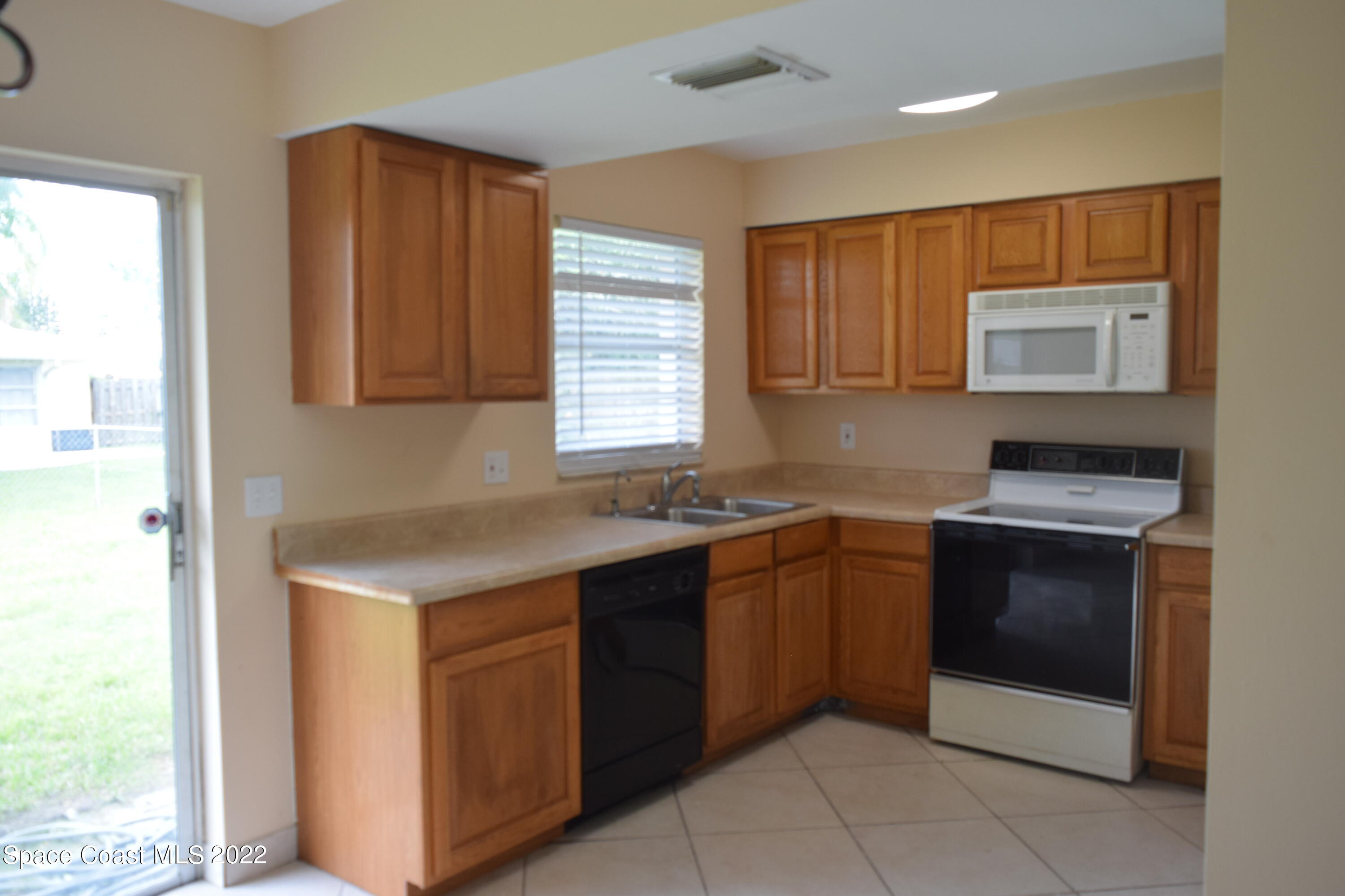 771 Cobblestone Lane Northeast Palm Bay, FL 32905 - Photo 7 of 30 a kitchen with stainless steel appliances granite countertop a stove a sink and a microwave