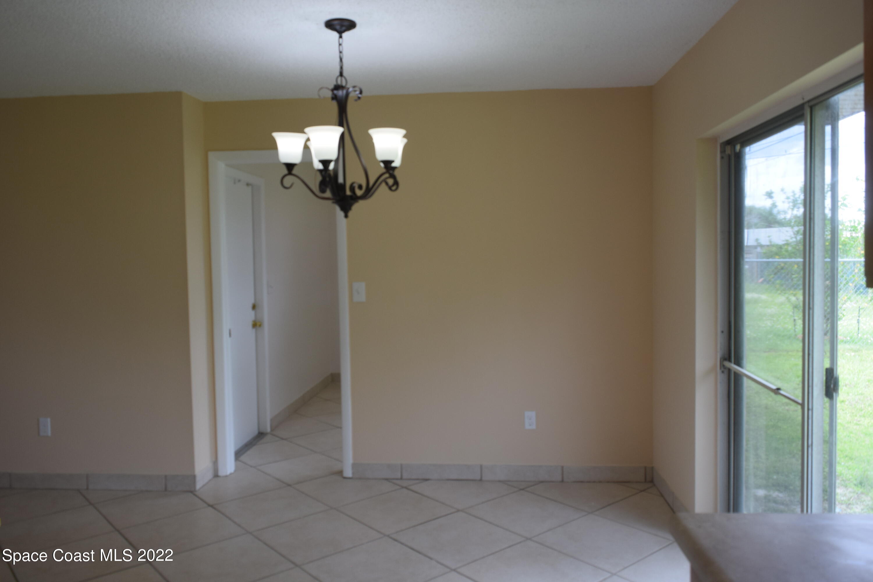 771 Cobblestone Lane Northeast Palm Bay, FL 32905 - Photo 10 of 30 a view of a chandelier in big room with windows
