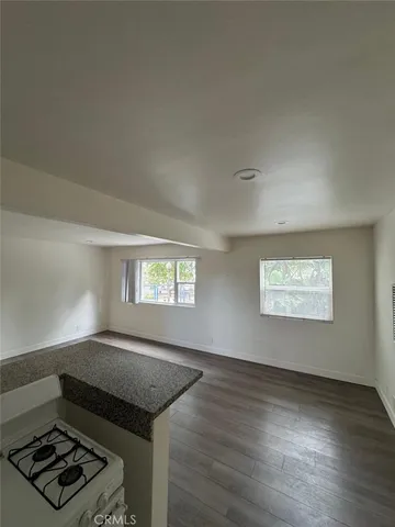 an empty room with windows and fireplace