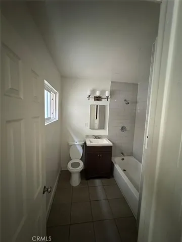 a bathroom with a granite countertop toilet sink and mirror