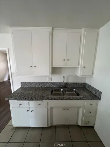 a kitchen with granite countertop white cabinets and a stove