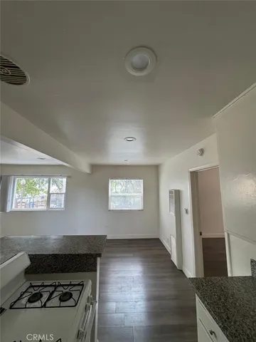 a kitchen with granite countertop a stove and a refrigerator