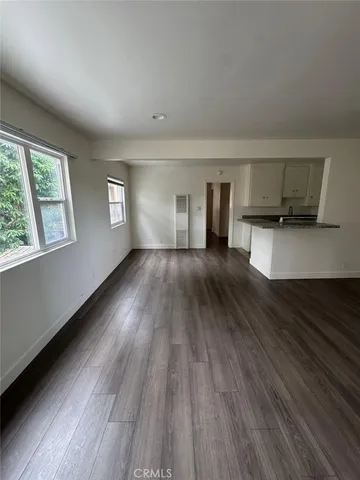 a view of a living room hardwood floor and a kitchen