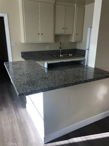 a kitchen with granite countertop a sink a stove and cabinets