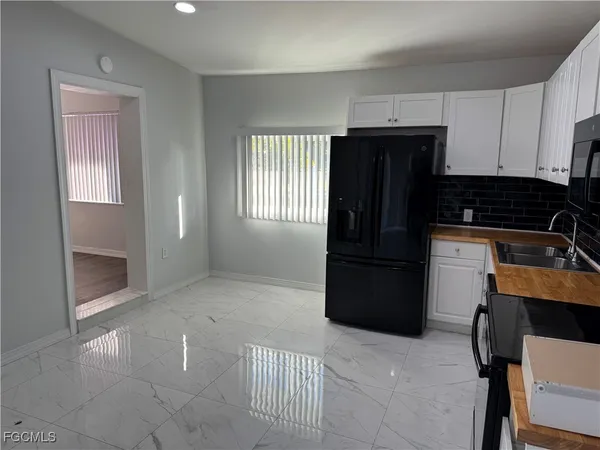 a kitchen with a refrigerator a stove top oven and cabinets