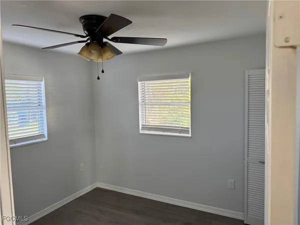 an empty room with a window and a fan