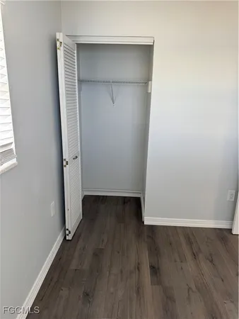 an empty room with wooden floor and closet