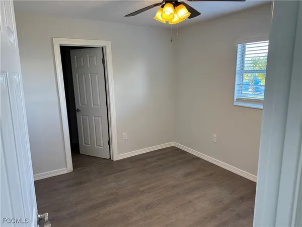 an empty room with wooden floor and closet