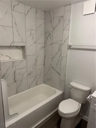 a white bath tub sitting next to a white toilet and sink
