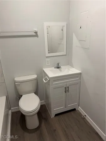 a bathroom with a toilet a sink and mirror