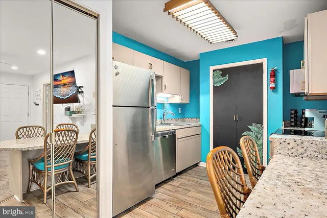 a kitchen with stainless steel appliances granite countertop a refrigerator and a sink