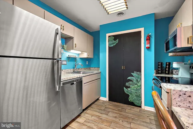 a kitchen with stainless steel appliances granite countertop a refrigerator and a stove