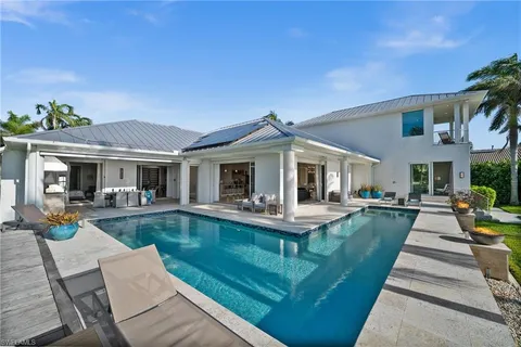 a view of a house with swimming pool and sitting area