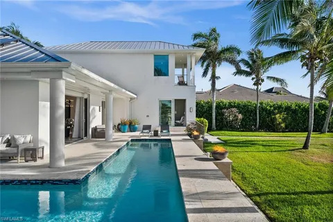 a view of a house with swimming pool and sitting area