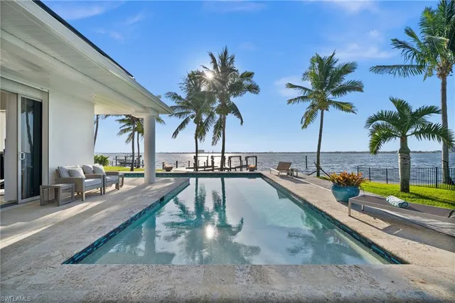 a swimming pool with outdoor seating and a garden